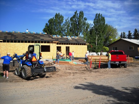 One work crew begins shingling the roof