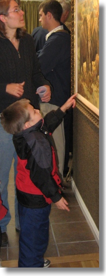 Child pointing to painting in art gallery