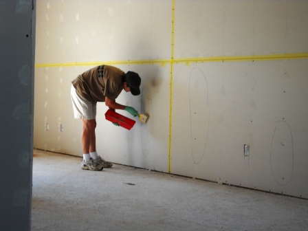 Taping drywall and mudding screws.